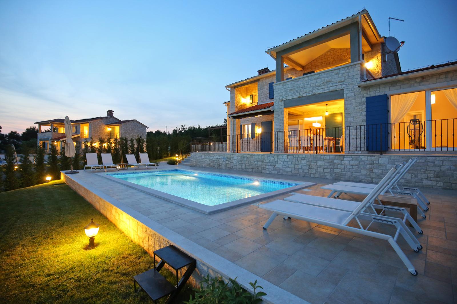 Villa Babudri and its pool lit up on a calm evening